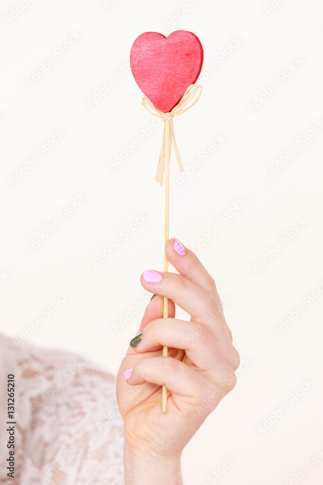 Woman holding heart shaped hand stick