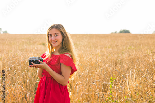 female photographer in the field with a camera taking pictures © satura_