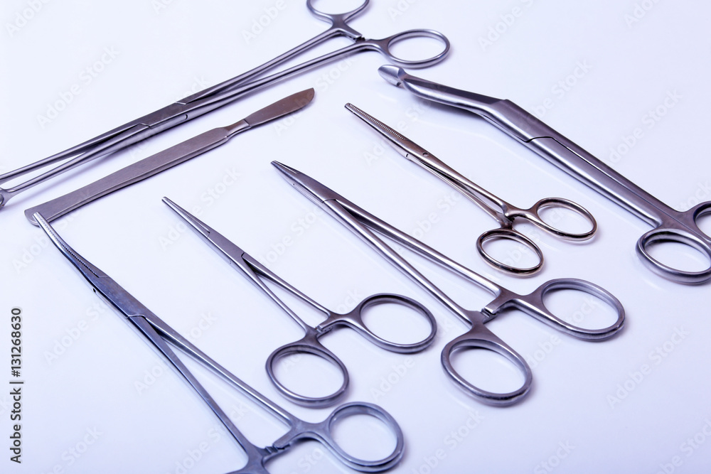 surgical instruments and tools including scalpels, forceps tweezers arranged on a table for surgery surgical instruments and tools including scalpels, forceps tweezers arranged on a table for surgery