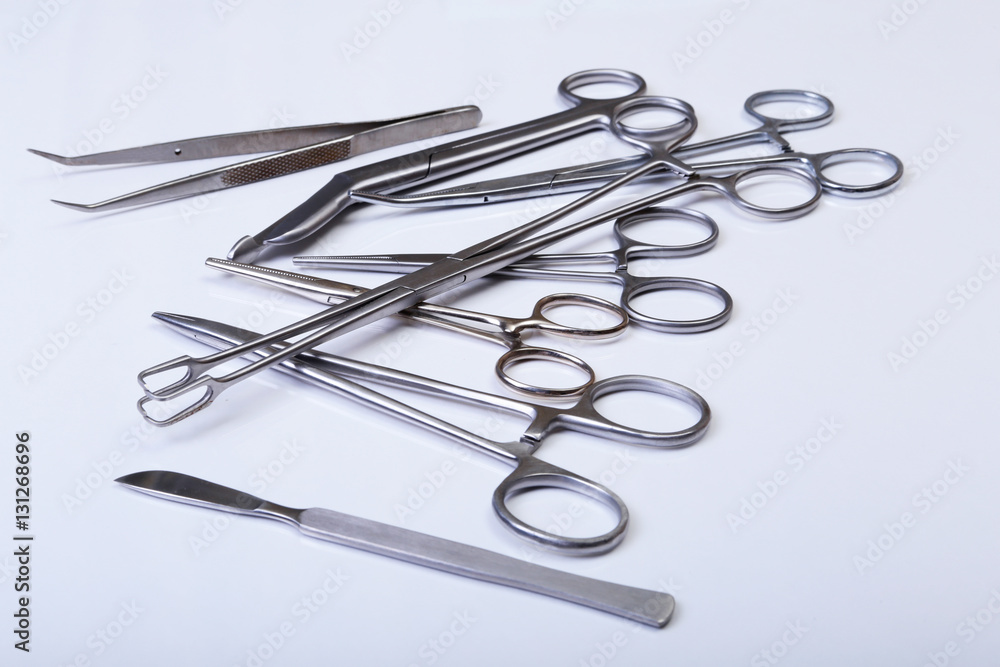 surgical instruments and tools including scalpels, forceps tweezers arranged on a table for surgery surgical instruments and tools including scalpels, forceps tweezers arranged on a table for surgery
