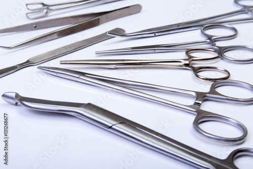 surgical instruments and tools including scalpels, forceps tweezers arranged on a table for surgery