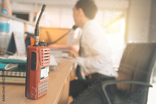 Walkie-talkie radio on wooden table operator in office. photo