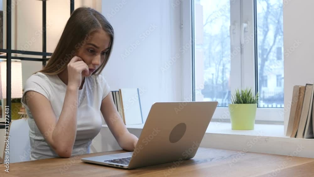 Pensive Young Girl Working on Laptop in Office Pensive Young Girl Working on Laptop in Office
