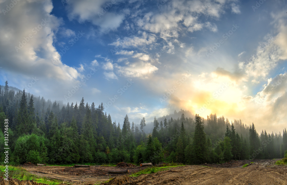 Fototapeta premium Bright sunrise in the fog and clouds in the mountainous landscap