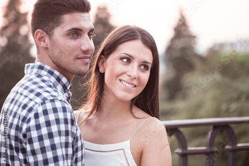 Smiling young and beautiful couple hugging at sunset