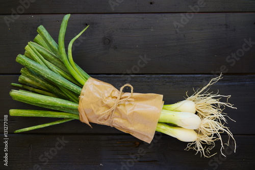 Raw food ingredients bouqet of spring onions on black boards photo