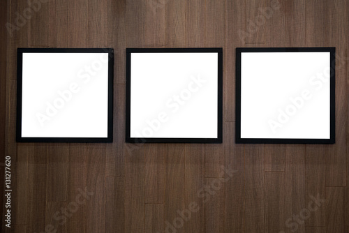 Three empty white isolated frame on the wood wall