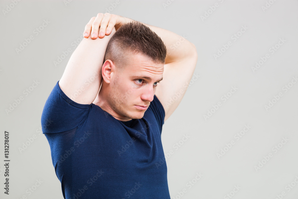 Studio shot image of young man who is stretching his body. Studio shot image of young man who is stretching his body.