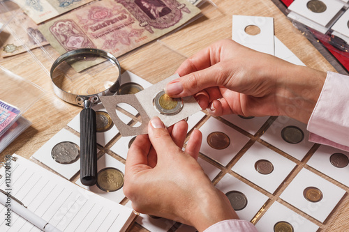 Woman looks at the collector s coin photo
