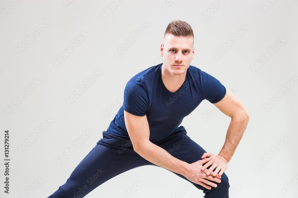Studio shot image of young man who is stretching his body. Studio shot image of young man who is stretching his body.