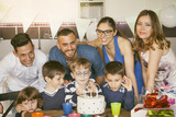 happy families with children celebrating around a cake for a bir