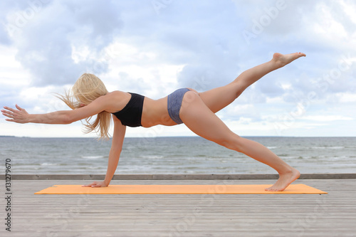Woman doing yoga at the sea