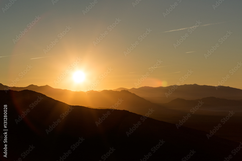 Backlit mountains and plains with a beautiful sunrise