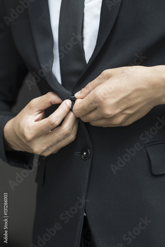 business man buttoning or unbuttoning expensive suit jacket