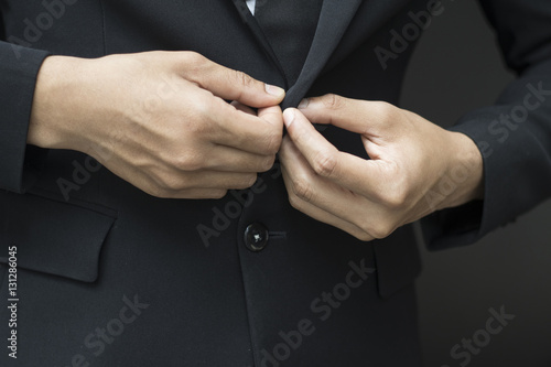business man buttoning or unbuttoning expensive suit jacket