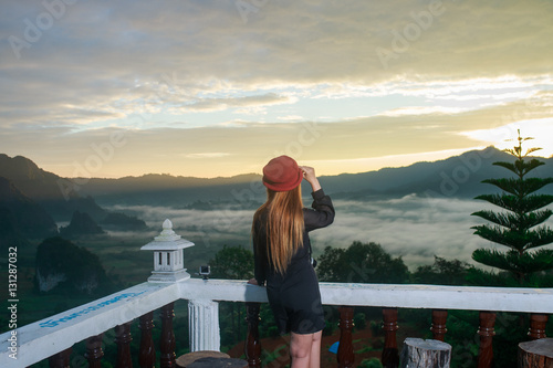 Woman look Sunrise and The Mist with Mountain Background , Lands
