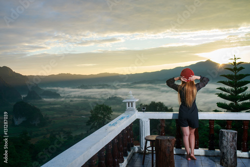 Woman look Sunrise and The Mist with Mountain Background , Lands