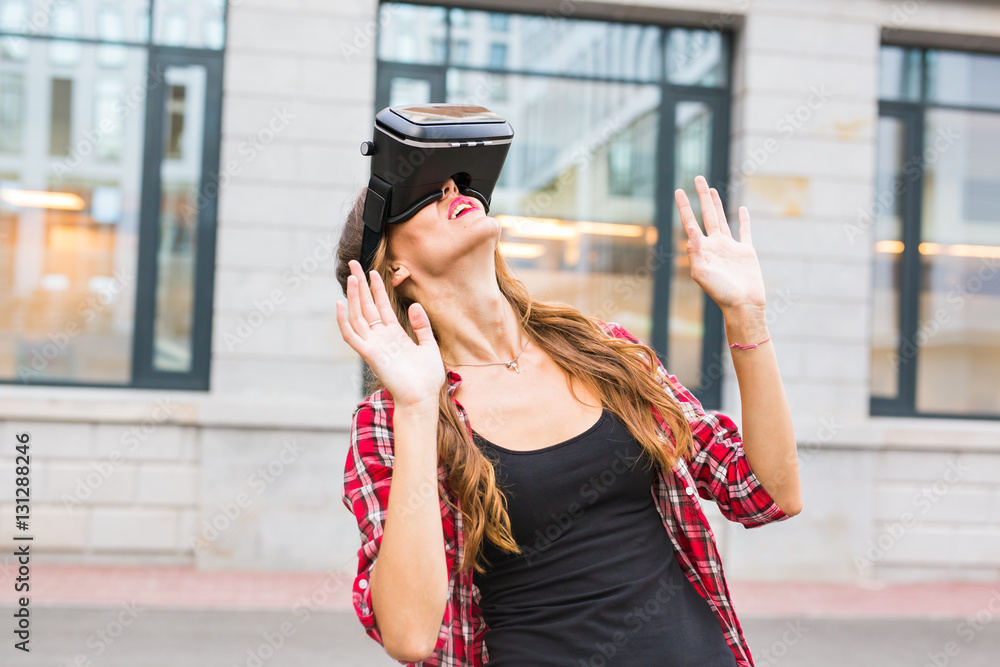 Young woman using high tech virtual reality glasses outdoor