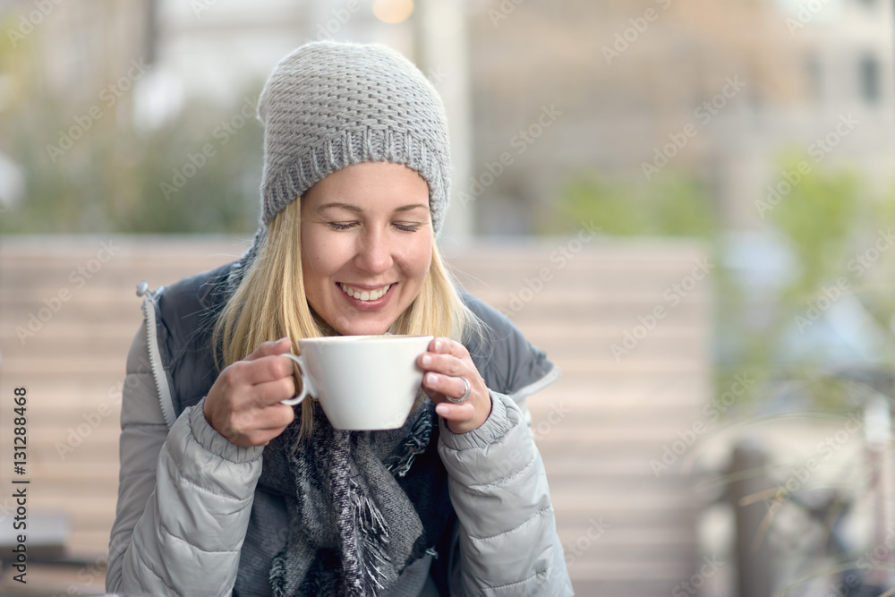 Junge Frau genießt einen heißen Kaffee im Winter Junge Frau genießt einen heißen Kaffee im Winter