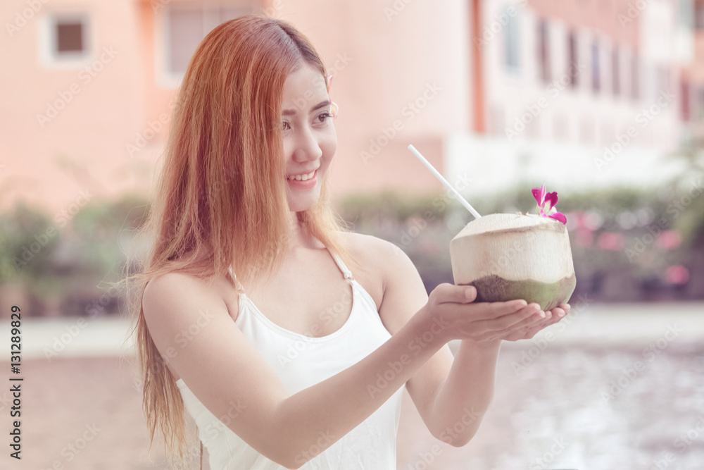 Young Asian woman is holding coconut ready to eat Young Asian woman is holding coconut ready to eat