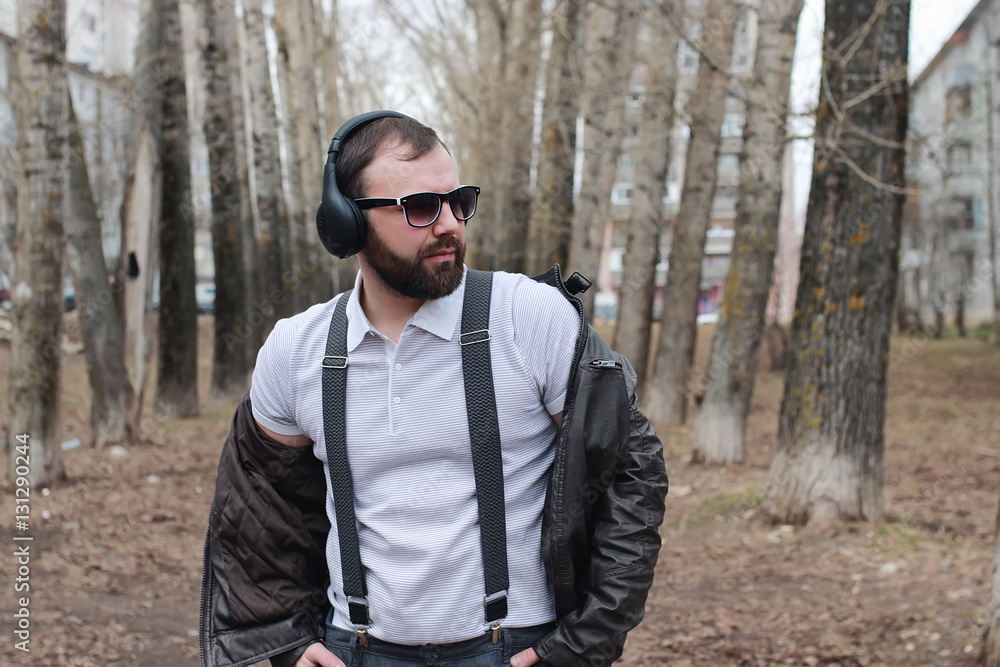 man with beard and headphones in the park man with beard and headphones in the park