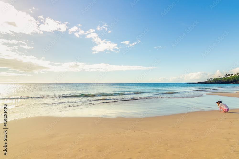 Fototapeta premium Young photographer taking pictures of sunset on the beach