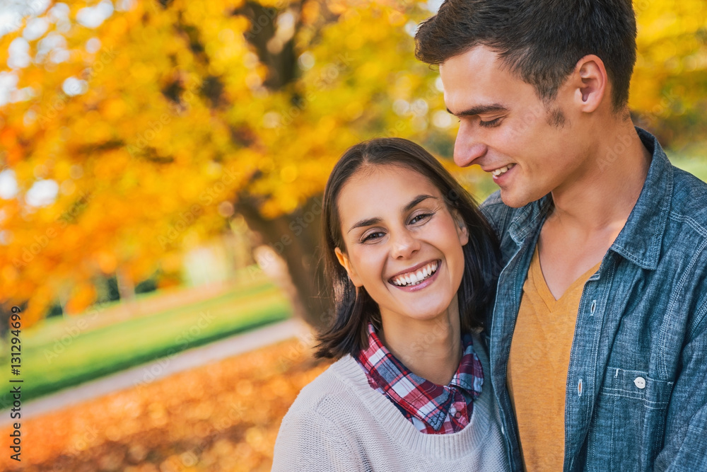 smiling young couple outdoors in park in autumn smiling young couple outdoors in park in autumn
