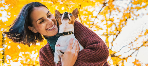 Canvas Print Portrait of young happy woman with little cute dog in park