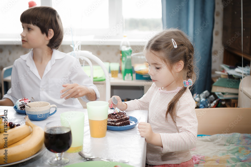 brother and sister sitting at home cake with candles