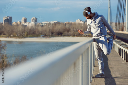 Man runner stretching legs before exercise run outdoors. Urban modern lifestyle healthy living concept. © lordn
