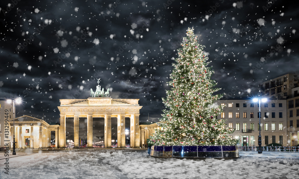 Obraz premium Brama Brandenburska w Berlinie z choinką w nocy i opadów śniegu