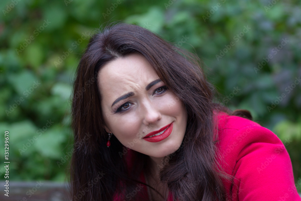 Portrait of expressive woman in a red coat. People Portrait of expressive woman in a red coat. People