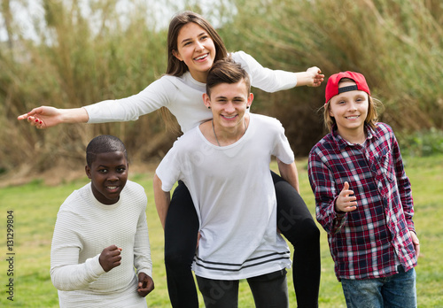 Portrait of laughing friends running on field