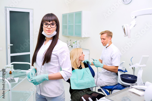 Dentist woman in glasses  on background equipment