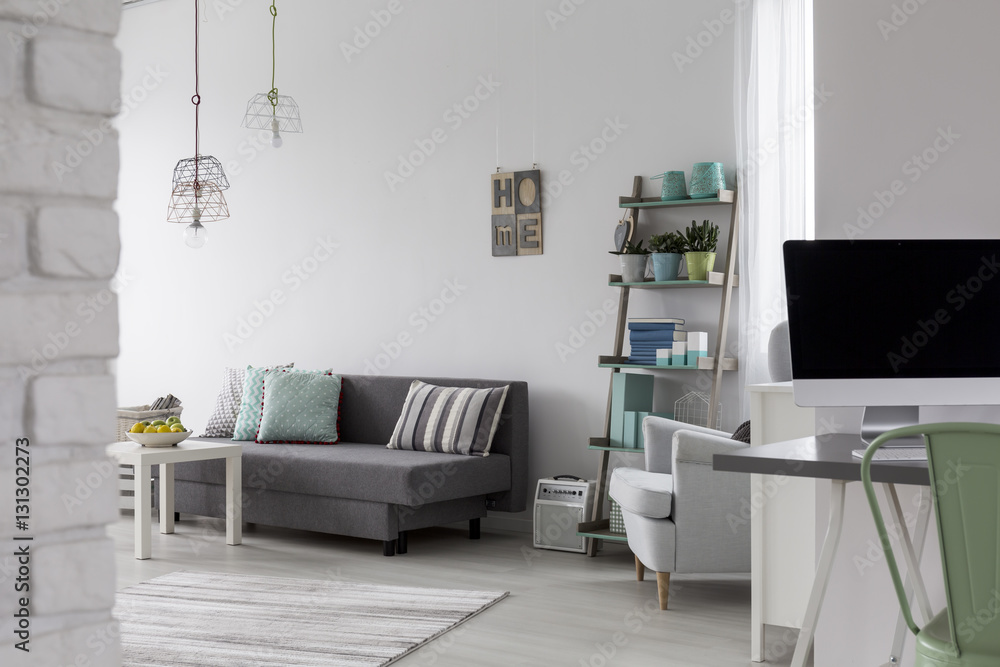 Living room with grey sofa, coffee table and white armchair Living room with grey sofa, coffee table and white armchair