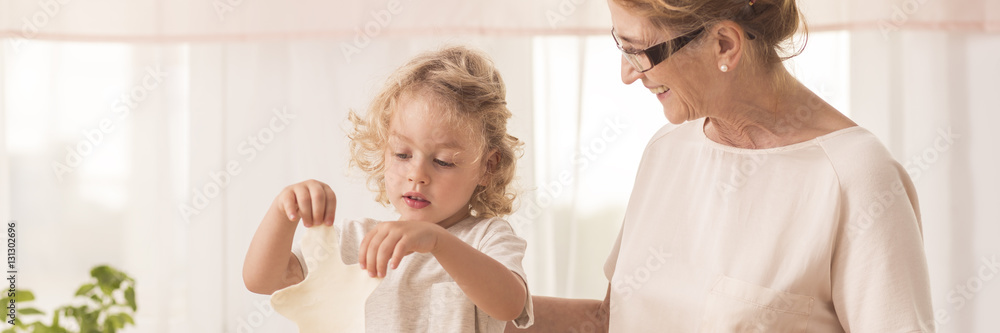 Boy cutting cookies with grandma Boy cutting cookies with grandma