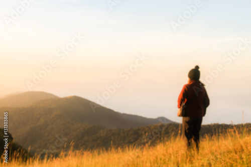 De focus or blurred young girl see mountain view in sunset