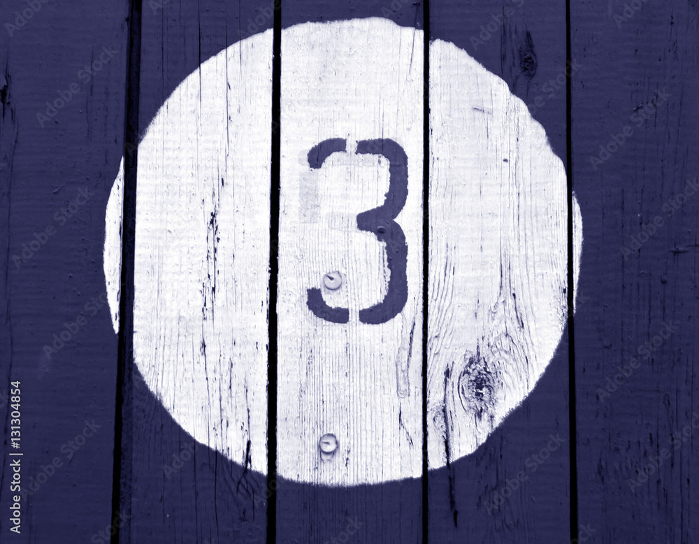 Number three on wooden blue toned wall. Number three on wooden blue toned wall.