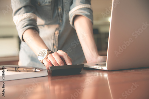Business women work with calculator and laptop,pen and notebook