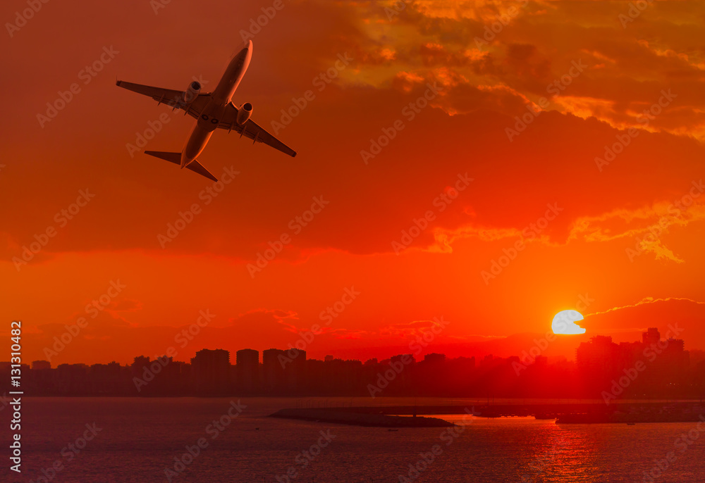 Passenger plane is landing away from airport at sunset Passenger plane is landing away from airport at sunset