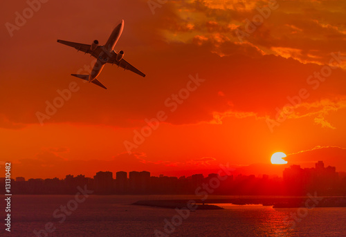 Passenger plane is landing away from airport at sunset