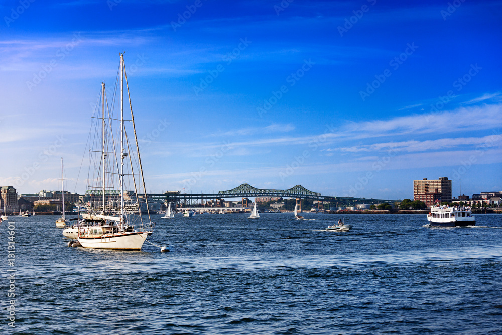 Boats in busy Boston Harbor with the Tobin Bridge in the background