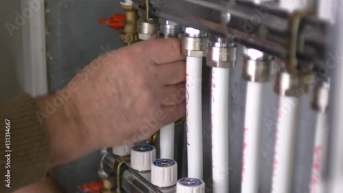 A man tightening the heating pipes of a central heating system