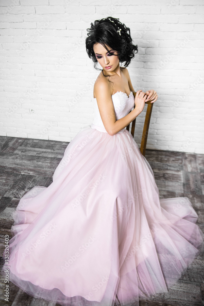 beautiful young brunette woman in a light pink long dress beautiful young brunette woman in a light pink long dress
