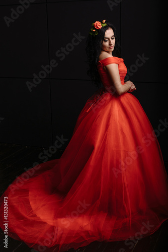 beautiful woman in the luxurious red dress on a black background
