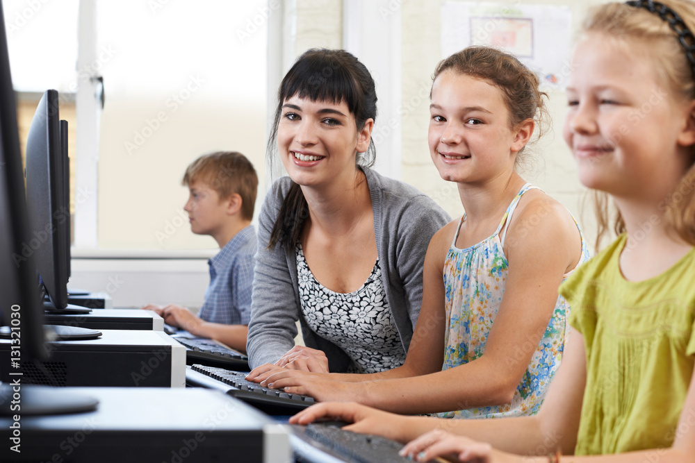 Fototapeta premium Female Elementary Pupil In Computer Class With Teacher