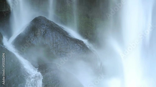 Close up footage of water falling on black rocks at Misol Ha waterfall in Mexico in high definition footage with ambient audio photo