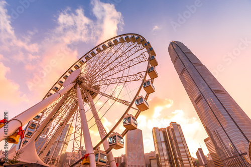 The popular icon Observation Wheel in Hong Kong island at sunset near Ferry Pier arera with landmark buildings in background.