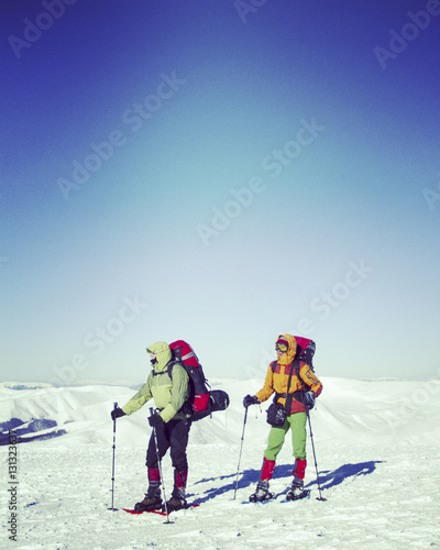 Winter hiking in the mountains on snowshoes with a backpack and