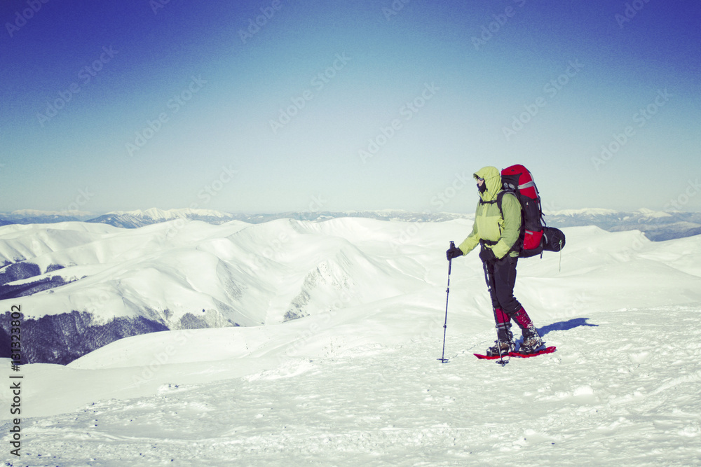 Winter hiking in the mountains on snowshoes with a backpack and